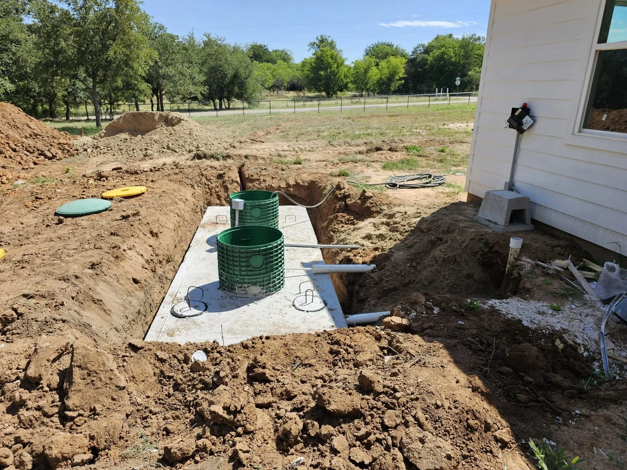 The finished tank with green risers and lids brought up to grade