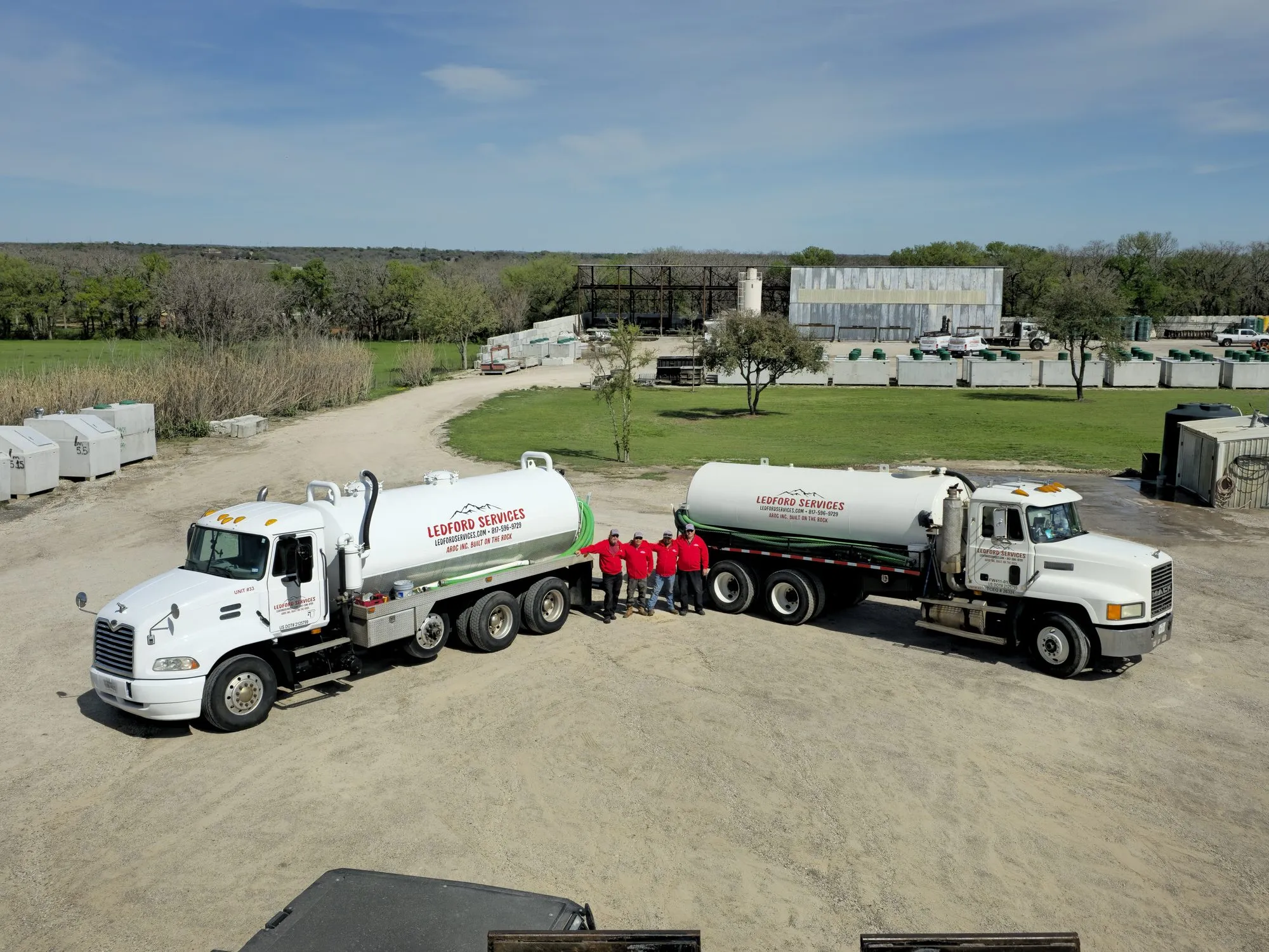 Ledford Services vacuum trucks and crew at the Aledo yard, with precast tanks stocked behind