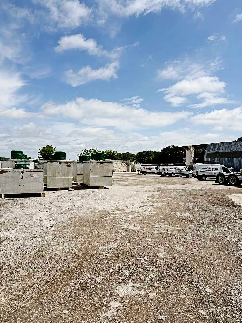 Ledford Services yard with precast septic tanks and service fleet